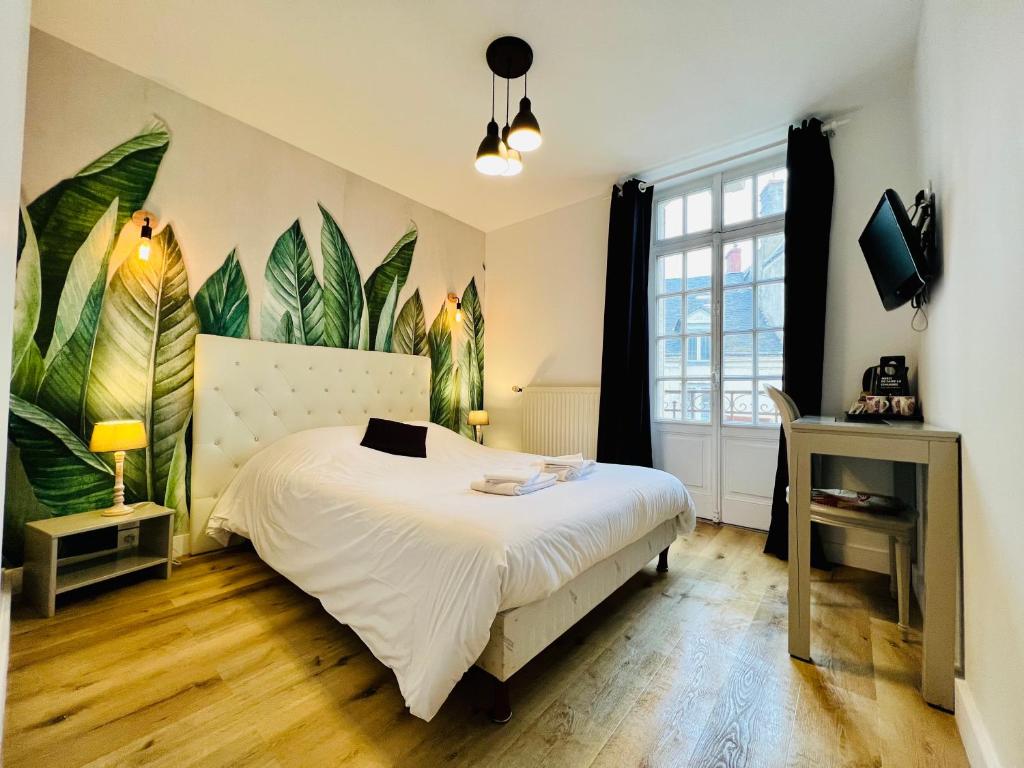 a bedroom with a bed and a large mural of leaves at Le Cheval Blanc in Jargeau