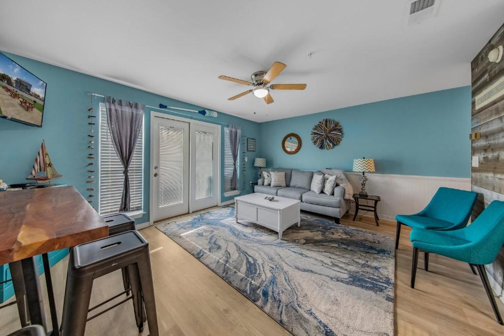 d'un salon avec des murs bleus et un ventilateur de plafond. dans l'établissement Grand Caribbean in Perdido Key 111E by Vacation Homes Collection, à Pensacola