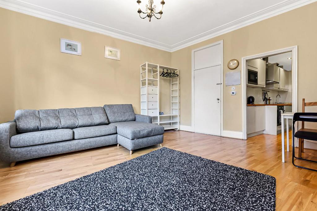 ein Wohnzimmer mit einem Sofa und einem Tisch in der Unterkunft Main Street Corner Great 1bedroom Flat - Richmond in London