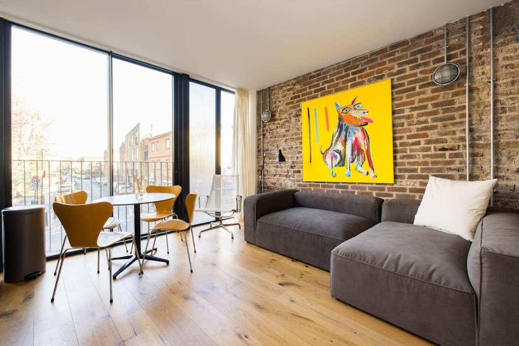 a living room with a couch and a brick wall at Cool Loft in fashionable East London in London