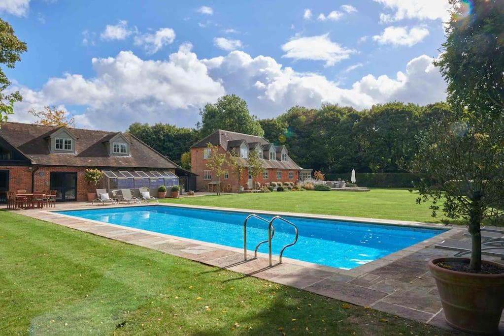 a swimming pool in the yard of a house at The Whistler's Perch in Buckinghamshire