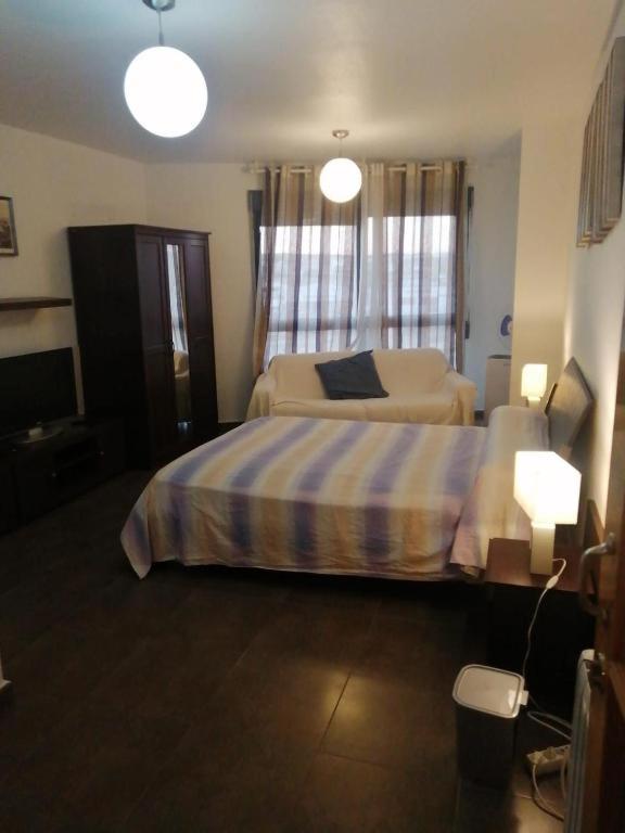 a bedroom with a bed and two lamps and a television at Apartamento Reina in Alcantarilla