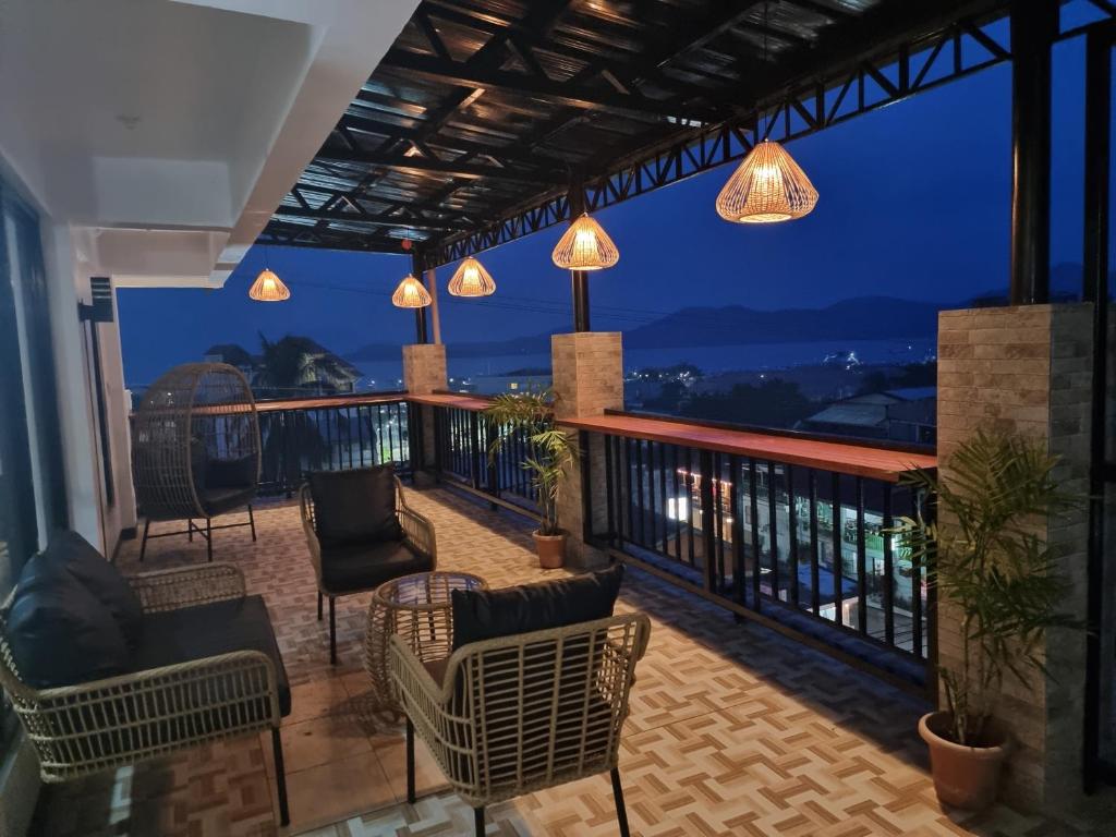 a balcony with chairs and lights at night at ISLANDERS INN - CORON in Coron