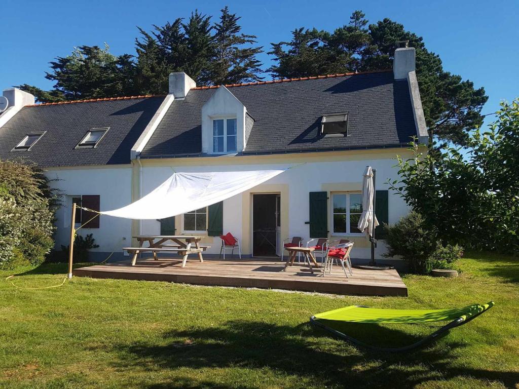 une maison blanche avec une table, des chaises et un parasol dans l'établissement Maison Bangor, 4 pièces, 7 personnes - FR-1-418-21, à Bangor