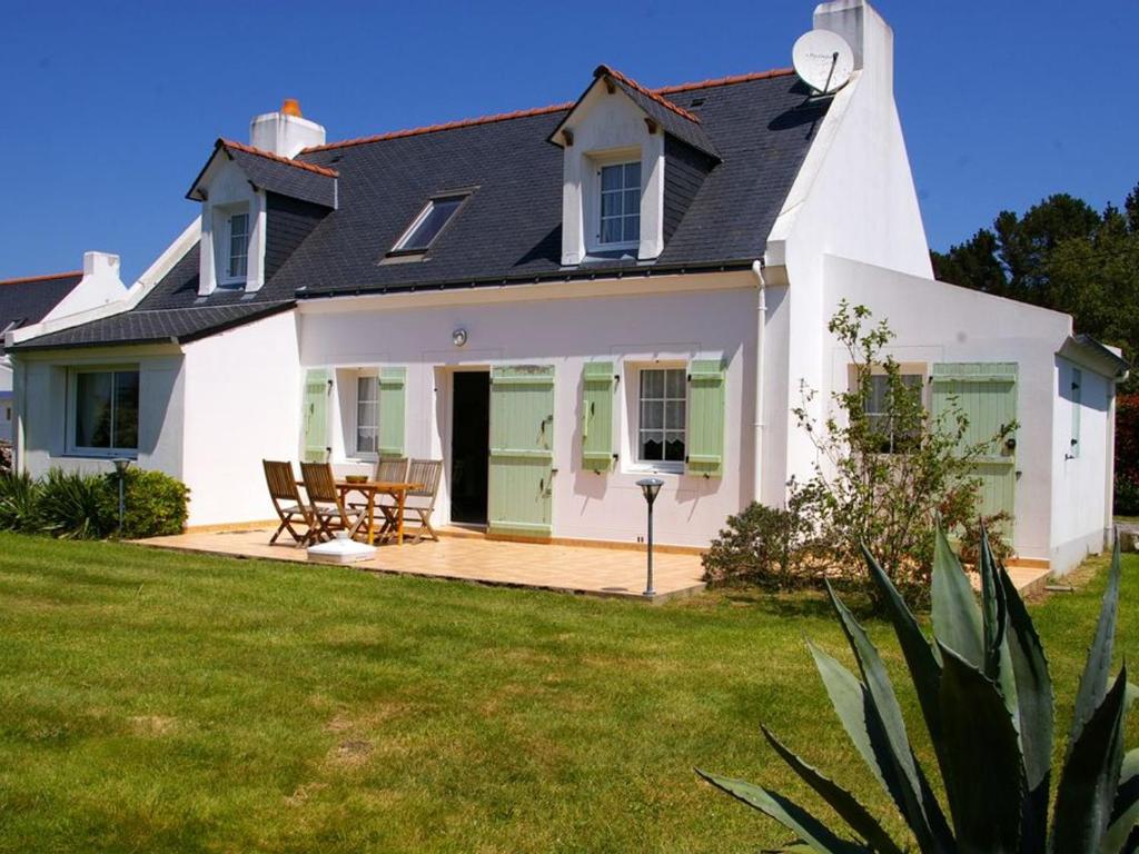 a white house with a patio and lawn at Maison Le Palais, 4 pièces, 7 personnes - FR-1-418-53 in Le Palais