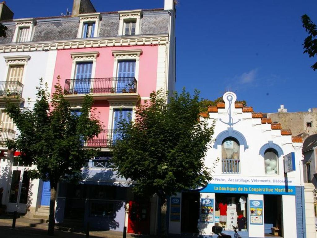 a pink and white building on a city street at Appartement Le Palais, 3 pièces, 4 personnes - FR-1-418-83 in Le Palais