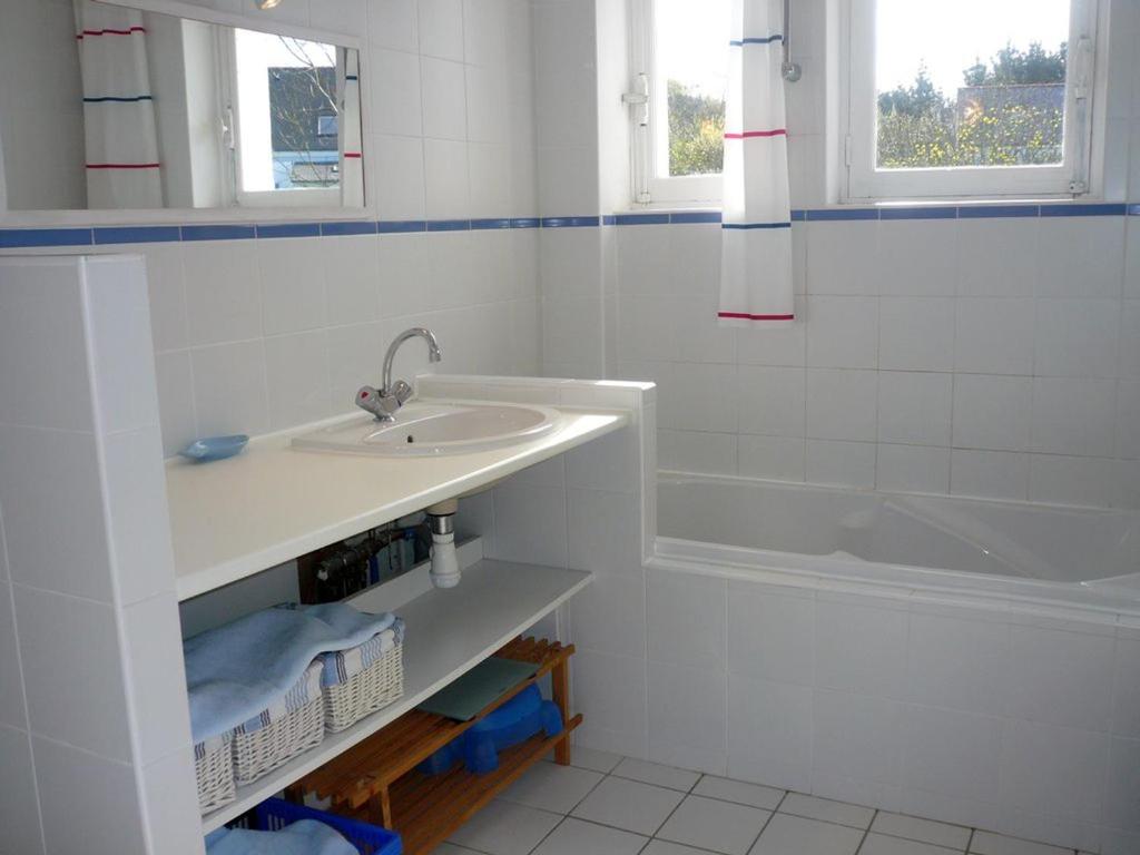 a white bathroom with a sink and a tub at Maison Le Palais, 5 pièces, 5 personnes - FR-1-418-76 in Le Palais