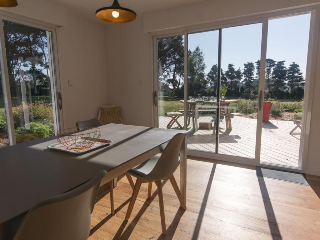 une salle à manger avec une table et des chaises ainsi qu'une terrasse dans l'établissement Maison contemporaine indépendante, proche plage et centre-ville, 4*, animaux acceptés, avec WIFI - FR-1-418-124, au Palais