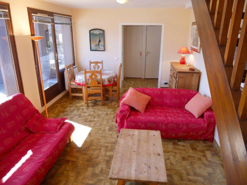 a living room with a red couch and a table at Duplex F2 avec terrasse vue lac, parking et WiFi – Annecy - FR-1-432-5 in Annecy