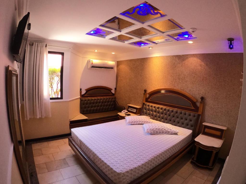 um quarto com uma cama grande e um tecto azul em Motel Villa di Roma (Adults Only) no Guarujá