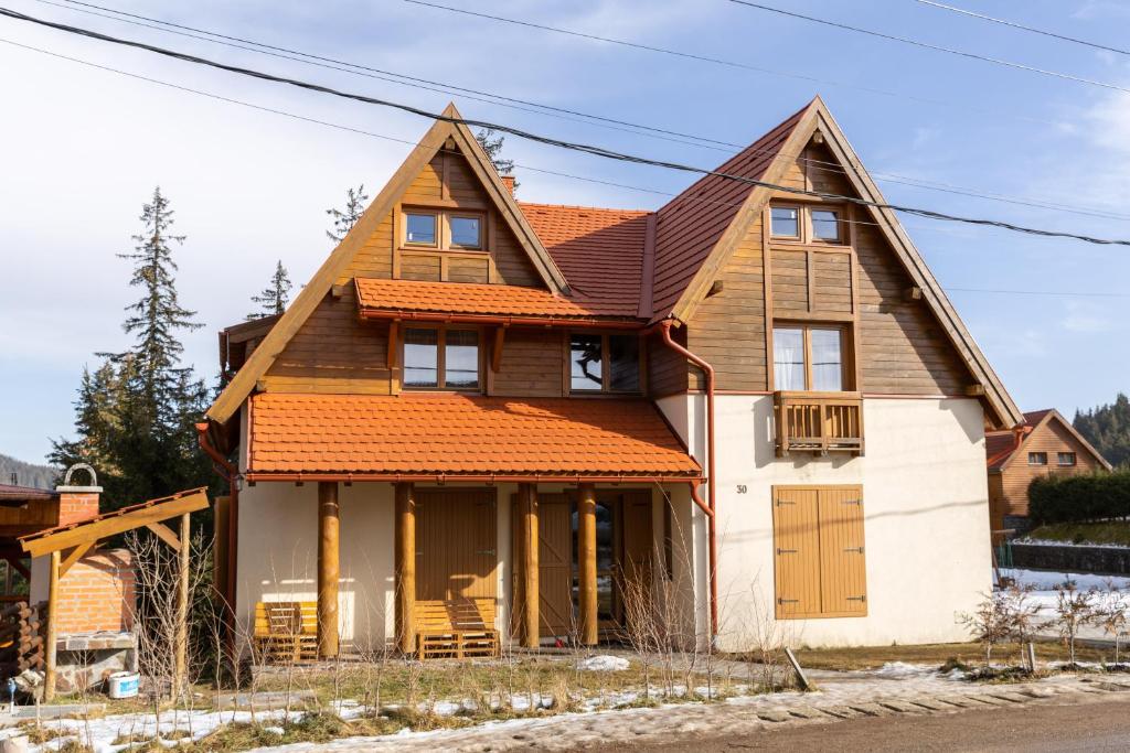una casa con techo naranja en Casa Bogát Ház en Harghita-Băi