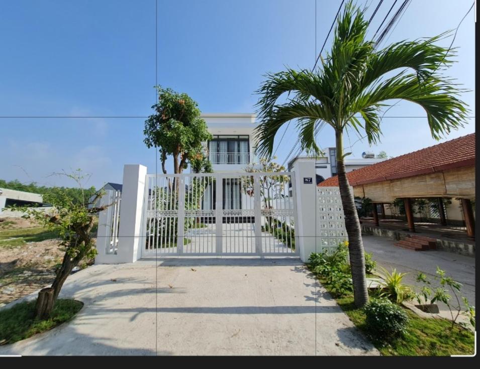 Hàm Tân的住宿－Sunrise House，房屋前有棕榈树的白色门