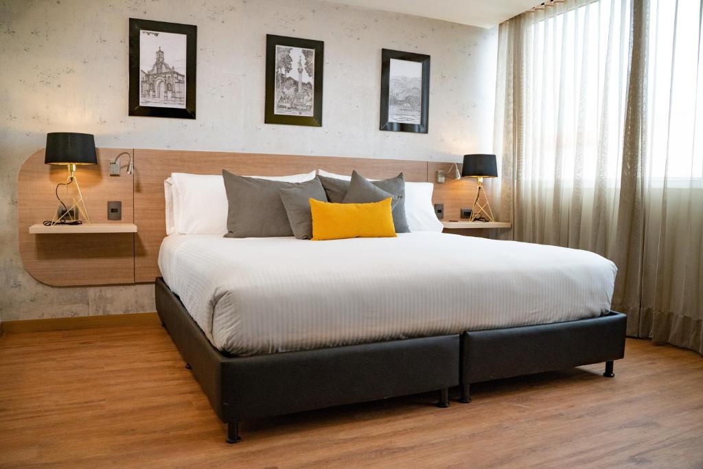 a bedroom with a large bed with a yellow pillow at Hotel Casino Internacional in Cúcuta