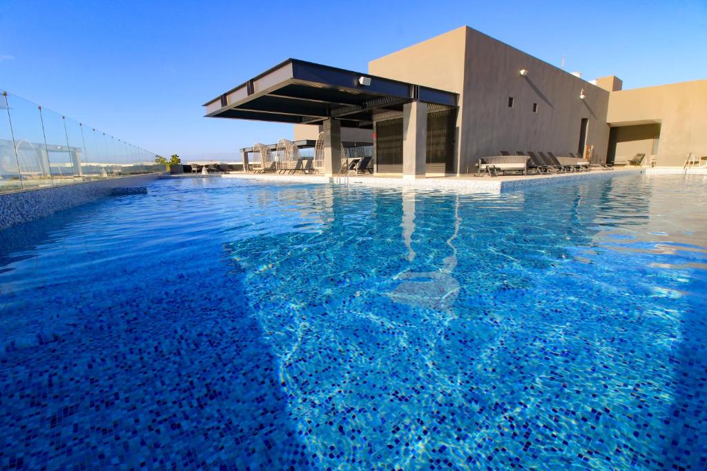 una piscina de agua azul frente a un edificio en Singular Dream Vacation Rentals en Playa del Carmen