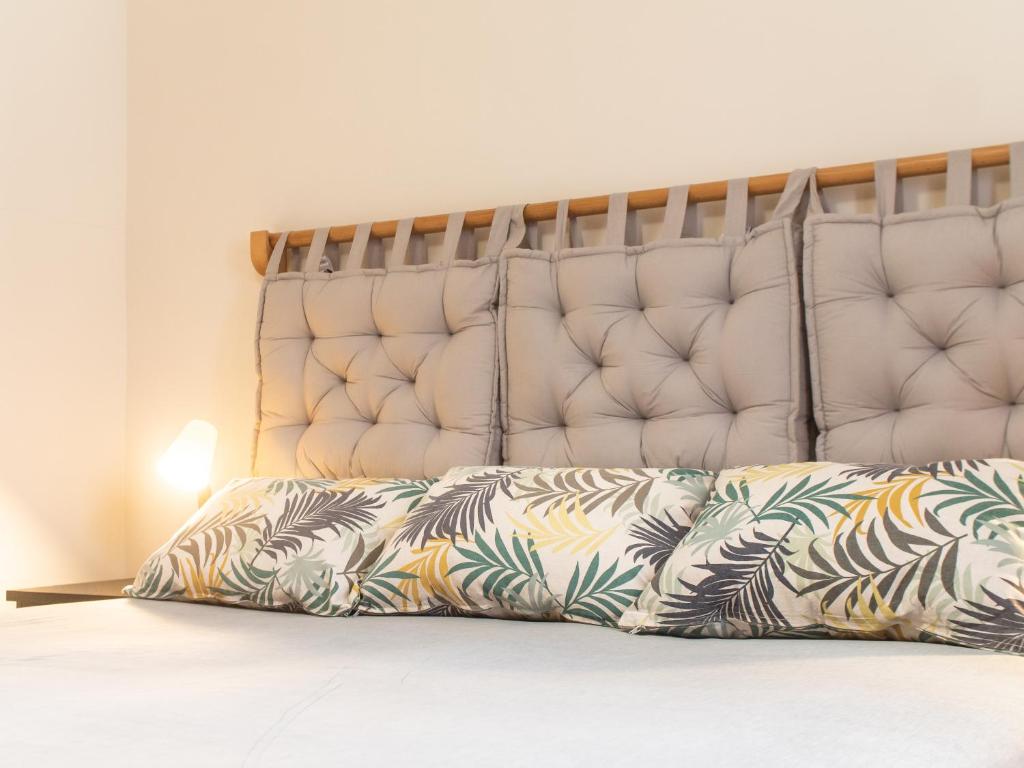 a bed with a large white headboard and pillows at Residencial Bia d'Olaf in Santa Maria