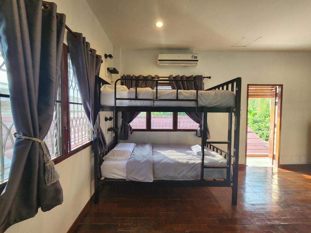 2 literas en una habitación con ventana en Blue Moon House - A budget hostel for easy travellers, en Chiang Mai