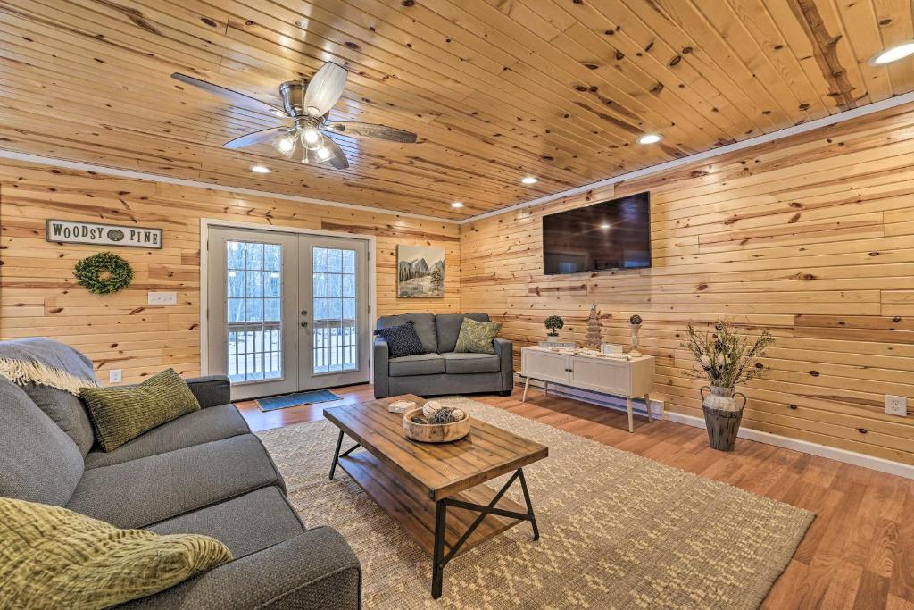 a living room with a couch and a table at Cozy Elmira Cabin with Deck, 23 Mi to Slopes! 