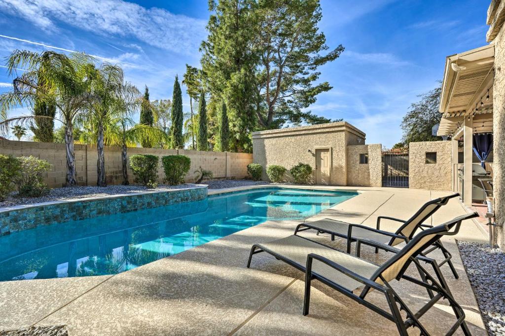 Scottsdale Home with Private Heated Pool في فينكس: مسبح مع كرسيين بجانب المنزل