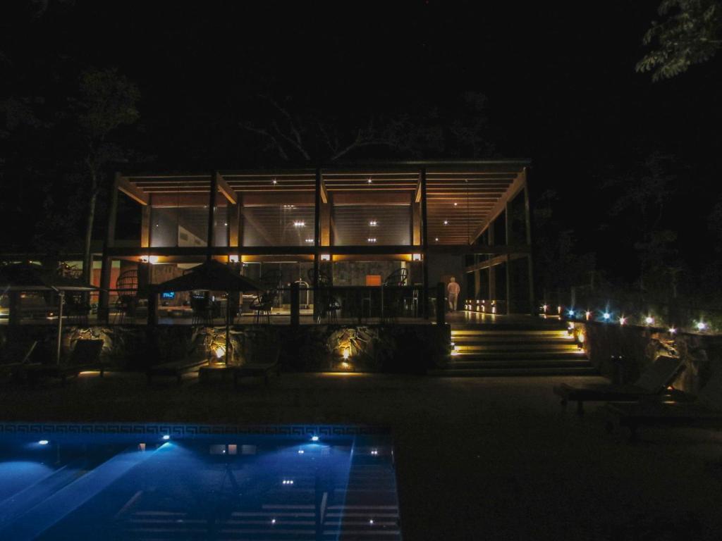 a building at night with a pool in front of it at Selvaje Lodge Iguazu in Puerto Iguazú