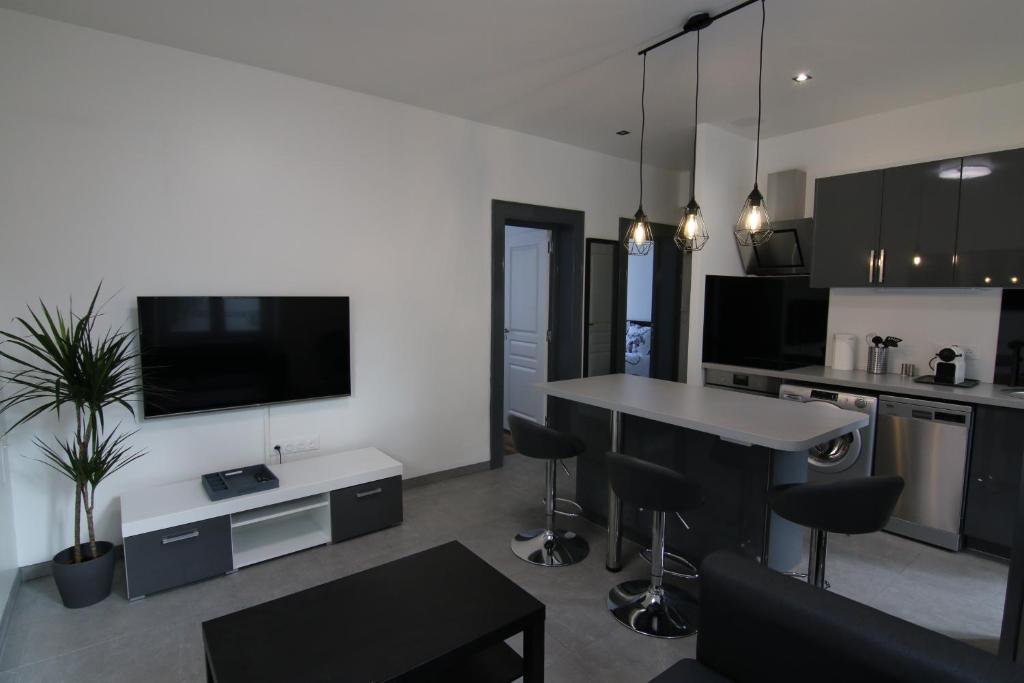 une cuisine et un salon avec une table et des chaises dans l'établissement Joli appartement avec petit jardin privatif, à Charleville-Mézières