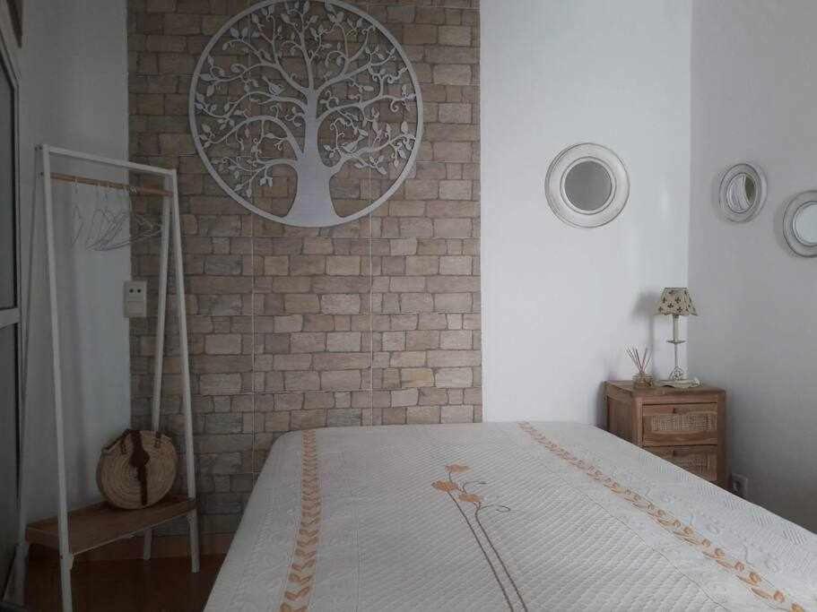 a bedroom with a bed and a brick wall at A Toca do Cuco na Vila da Sertã in Sertã