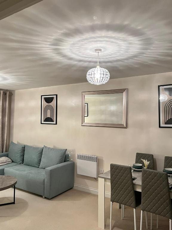 a living room with a couch and a chandelier at stylish luxe apartment in Harlow