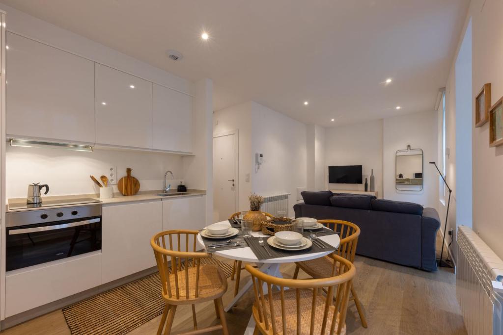 eine Küche und ein Wohnzimmer mit einem Tisch und Stühlen in der Unterkunft CoruñaFlat Apartamentos con encanto en el centro de A Coruña in A Coruña