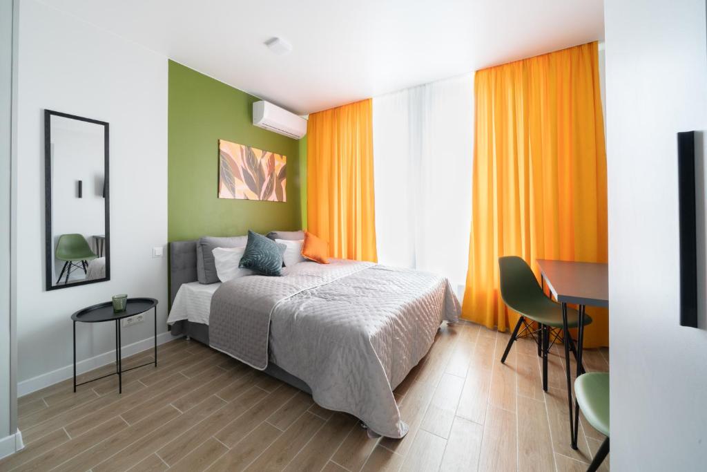 a bedroom with a bed and a table and a desk at MYFREEDOM Апартаменти метро Нивки in Kyiv