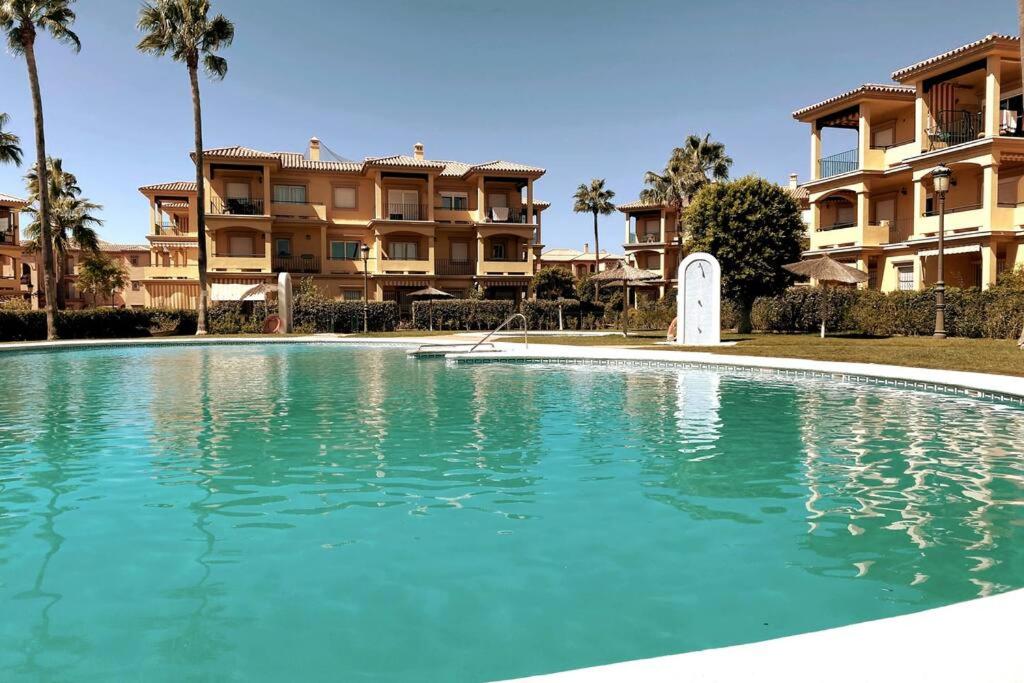 een zwembad voor sommige appartementsgebouwen bij Novo Sancti Petri, La Barrosa, 2 Beds Room Apartamento by Chiclana Dreams in Chiclana de la Frontera