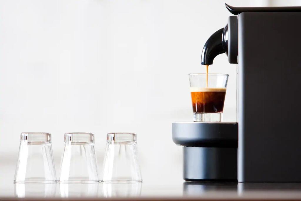 three wine glasses and a coffee maker on a table at LivinParis - Luxury 3 Bedrooms République I in Paris