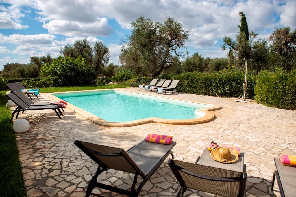 una piscina con sillas y una mesa junto a ella en Casa Papavero, en San Michele Salentino