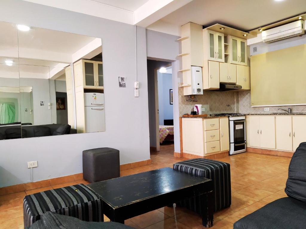 cocina y sala de estar con mesa y sillas. en Apartamentos Centro en San Salvador de Jujuy