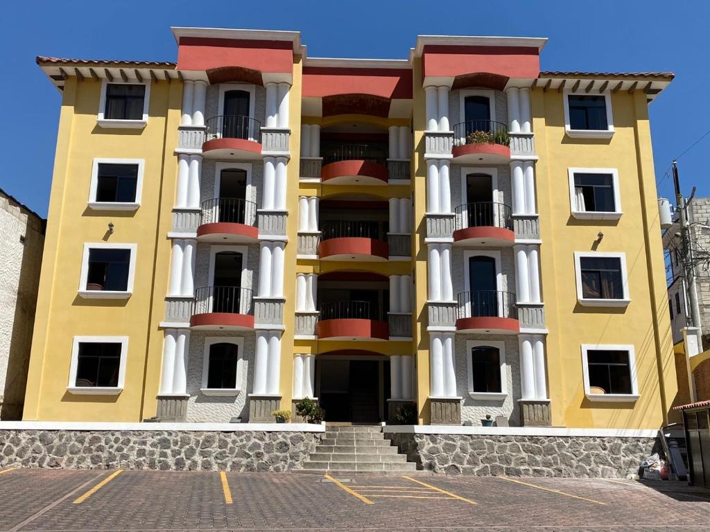 a large yellow building with balconies on a street at Apartamento #4 Portal de Occidente in Quetzaltenango