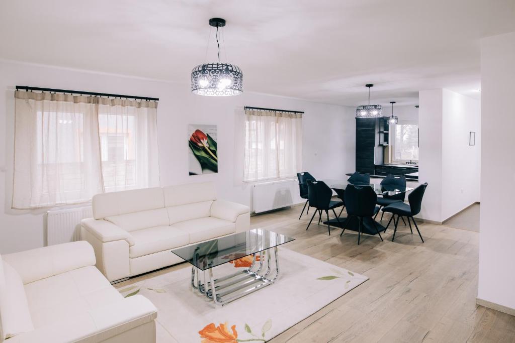 uma sala de estar com um sofá branco e uma mesa em Tulip Guest House I. em Palić