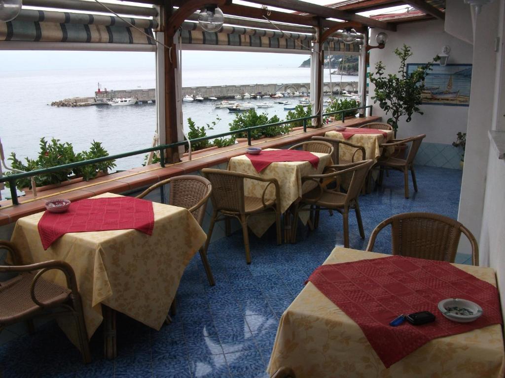 una fila de mesas y sillas en un restaurante en Holidays Baia D'Amalfi en Amalfi