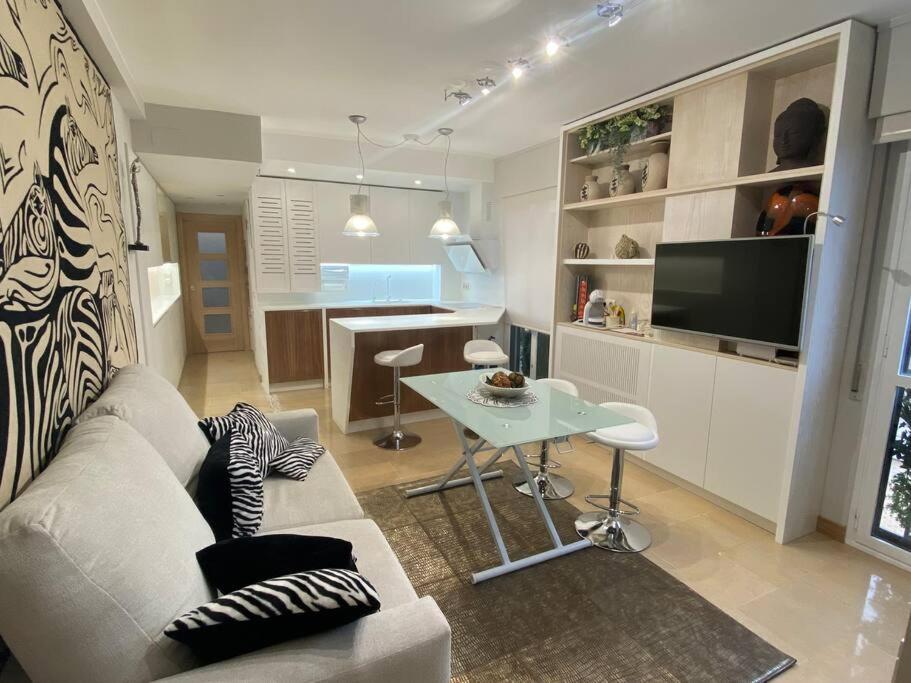 sala de estar con sofá blanco y mesa en Acogedor apartamento con acabados primera calidad, en Zaragoza