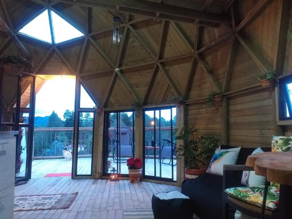 una sala de estar con un gran techo de madera. en Unique Glamping / Domo Betsaida en Guatapé