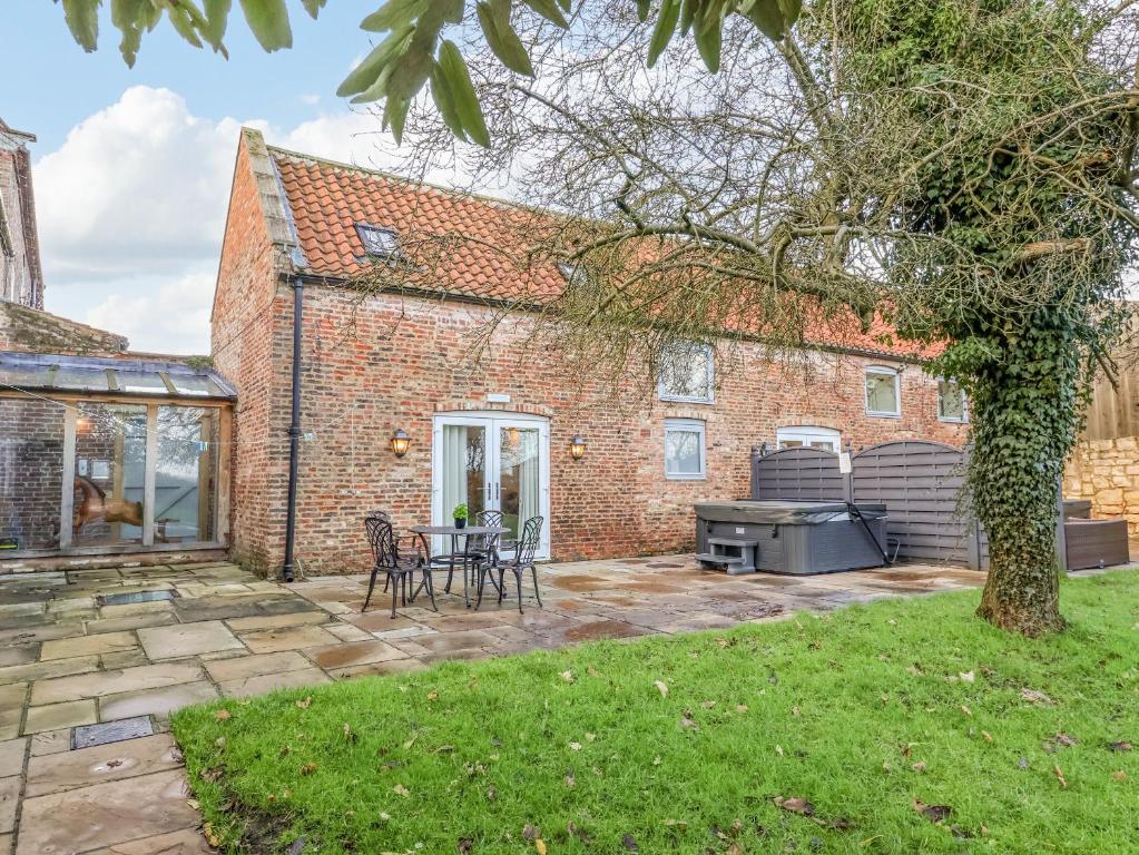 a brick house with a patio and a grill at Servant's Quarters in York