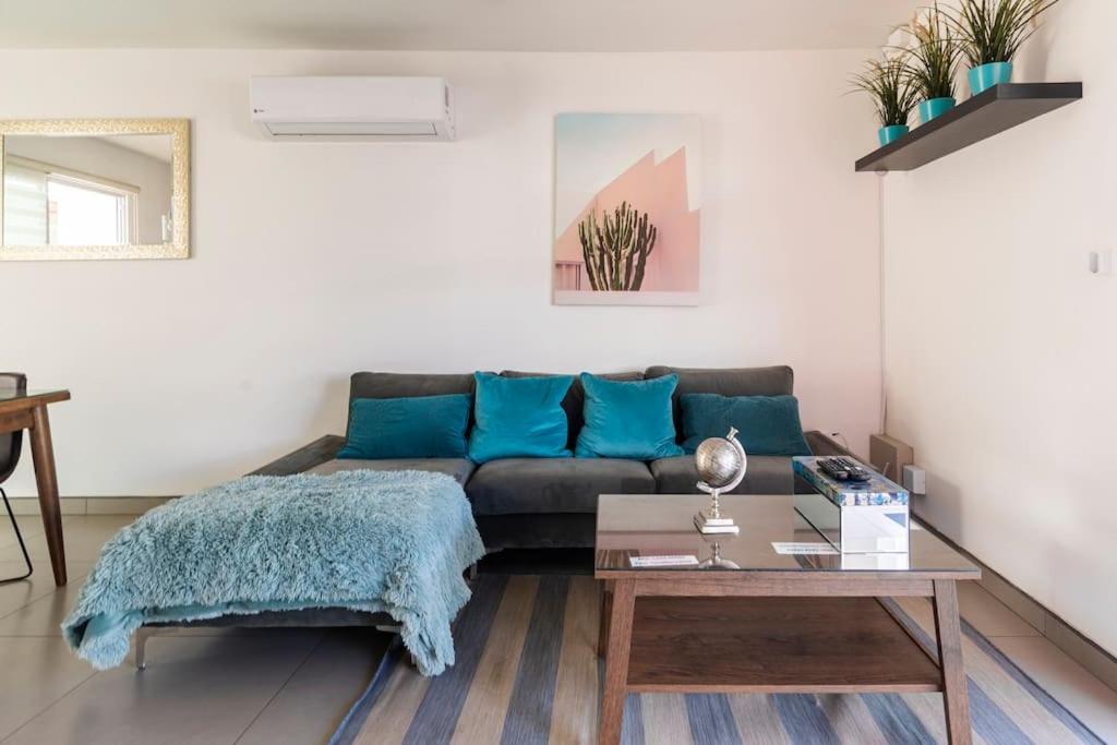 uma sala de estar com um sofá e uma mesa em #CasaMare - Privada a una cuadra del mar con AC em Ensenada