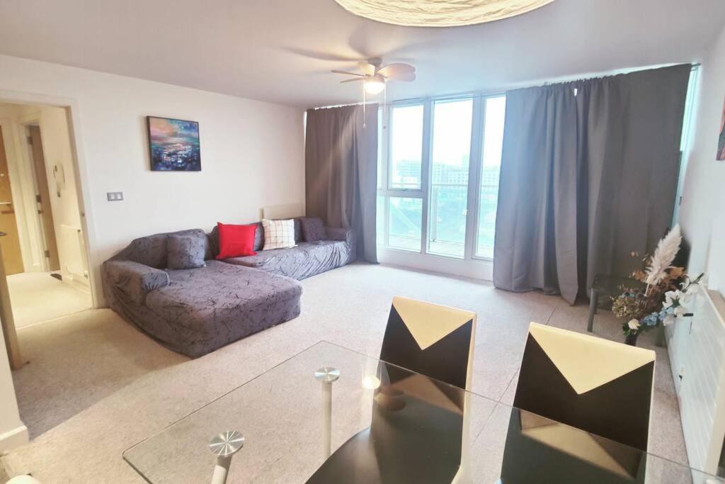 a living room with a couch and a glass table at Custom House Apartments in London