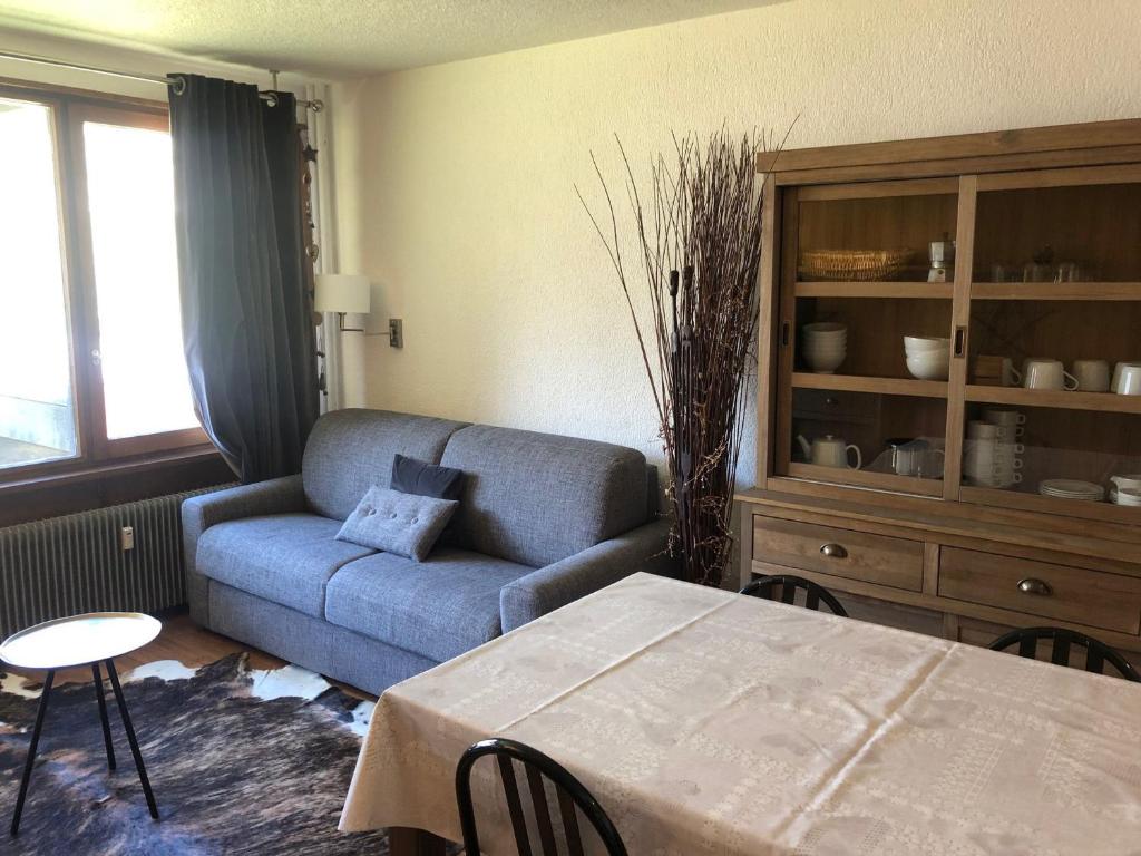 ein Wohnzimmer mit einem blauen Sofa und einem Tisch in der Unterkunft Appartement Tignes, 2 pièces, 5 personnes - FR-1-449-76 in Tignes