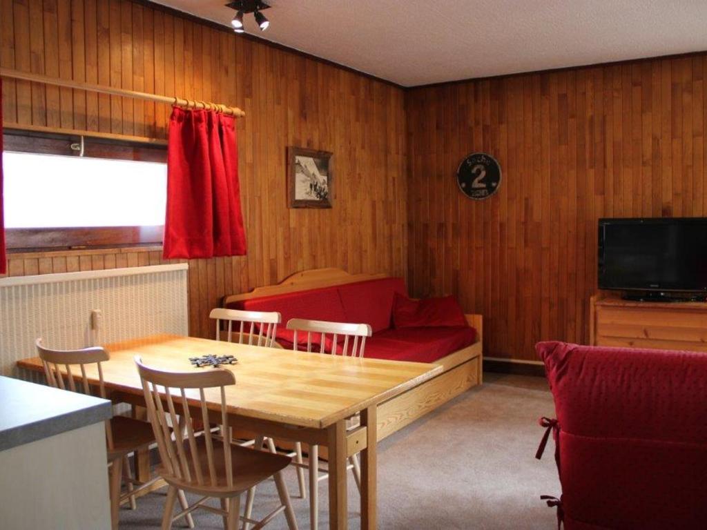 ティーニュにあるAppartement Tignes, 2 pièces, 6 personnes - FR-1-449-93のベッド、テーブル、椅子が備わる客室です。