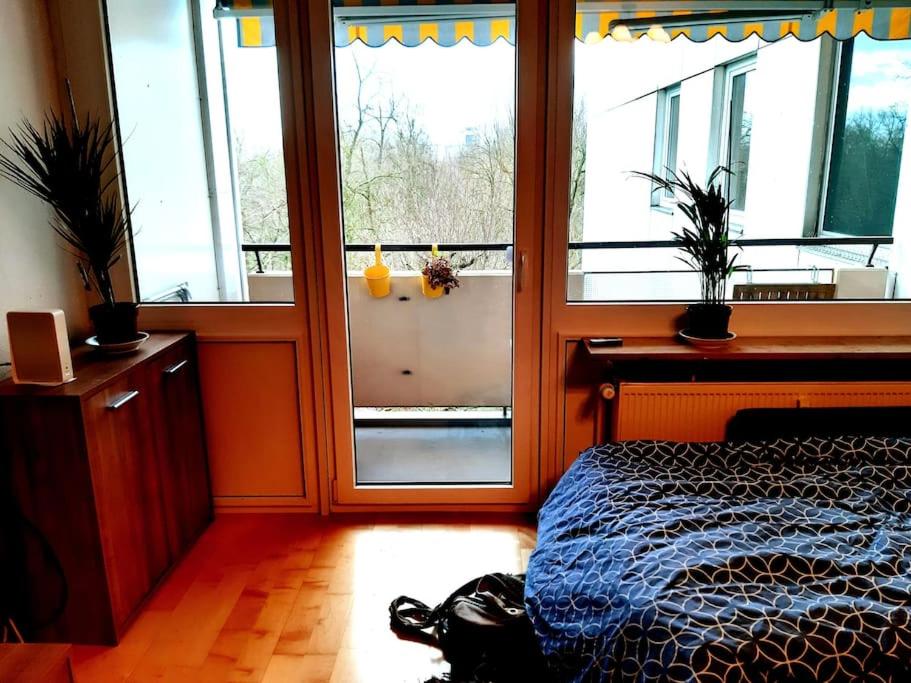 ein Schlafzimmer mit einem Bett und einem großen Fenster in der Unterkunft Zentral und doch Natur in Köln