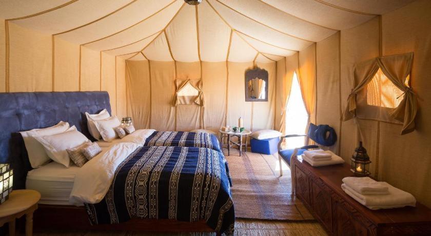 Säng eller sängar i ett rum på Sahara luxury camp & activities