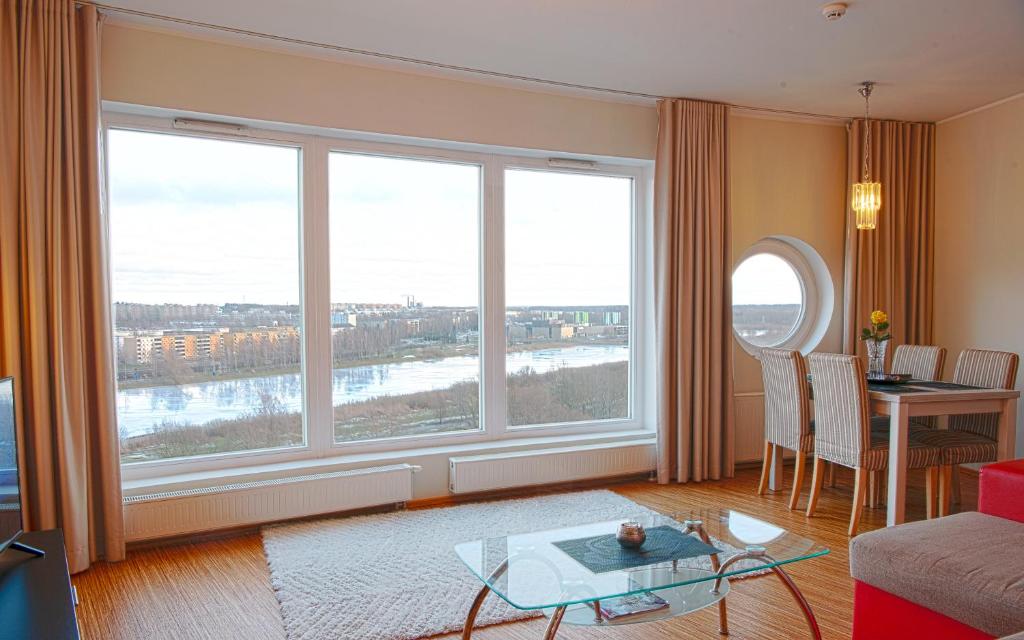 Sala de estar con 2 ventanas grandes y mesa en Wilde Guest Apartment Tigutorn en Tartu