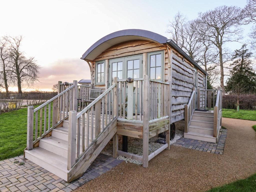 a wooden cabin with stairs and a window at The Storyteller in York