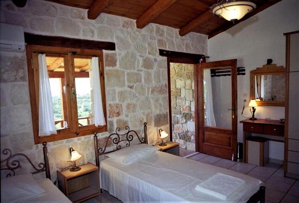 a bedroom with two beds and two windows at Villa Belvedere - 4 bedrooms Sea view House in Vasilikos