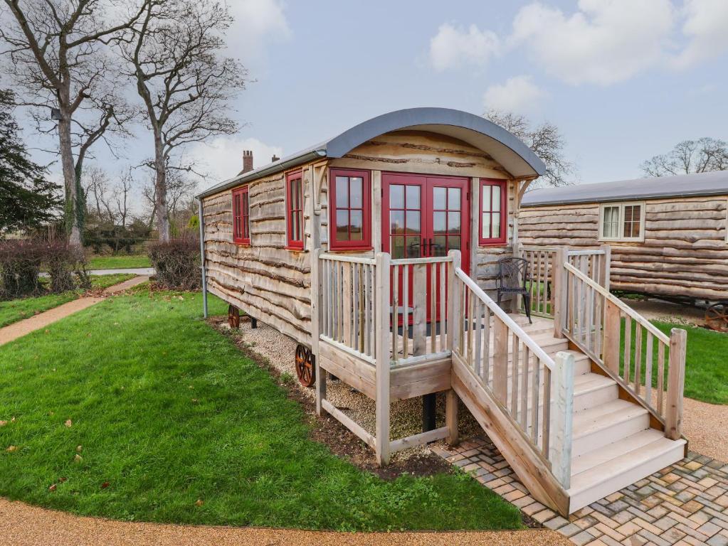 a small log cabin with a porch and a deck at The White Princess in York