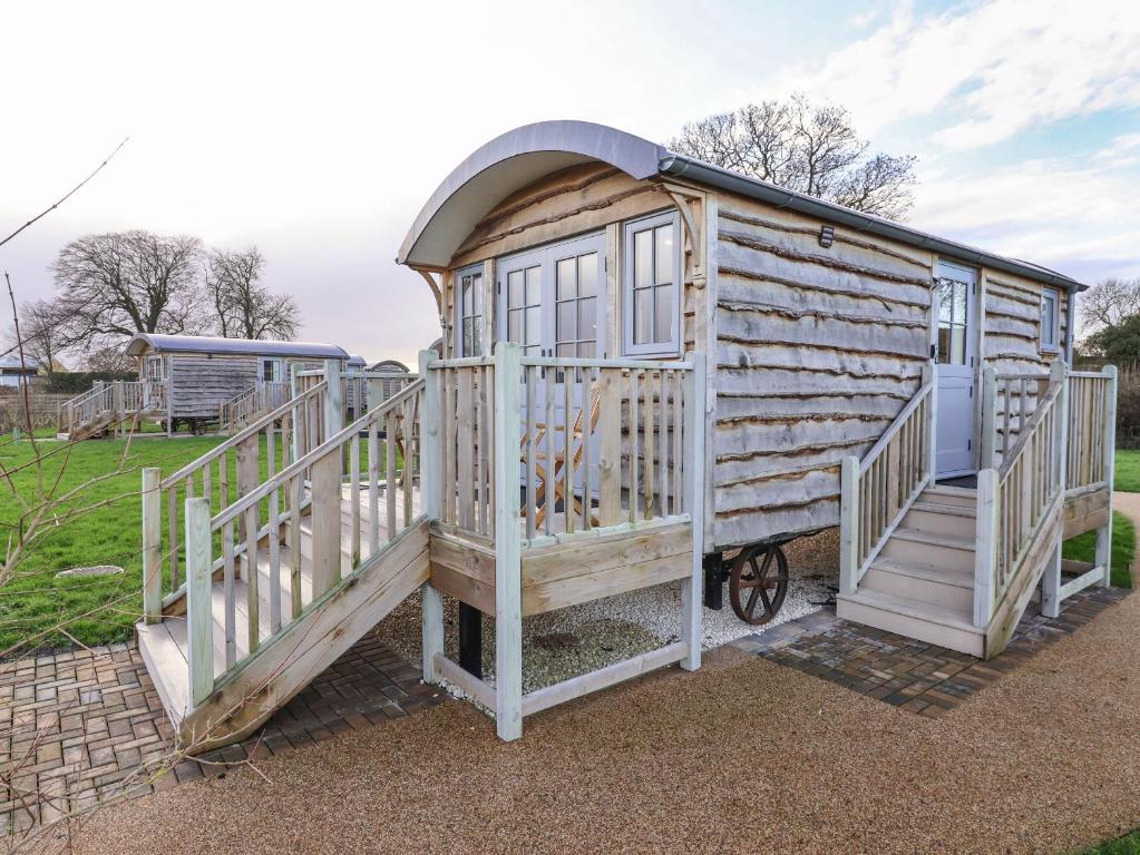 a large wooden cabin with a door and a staircase at The Fenton in York