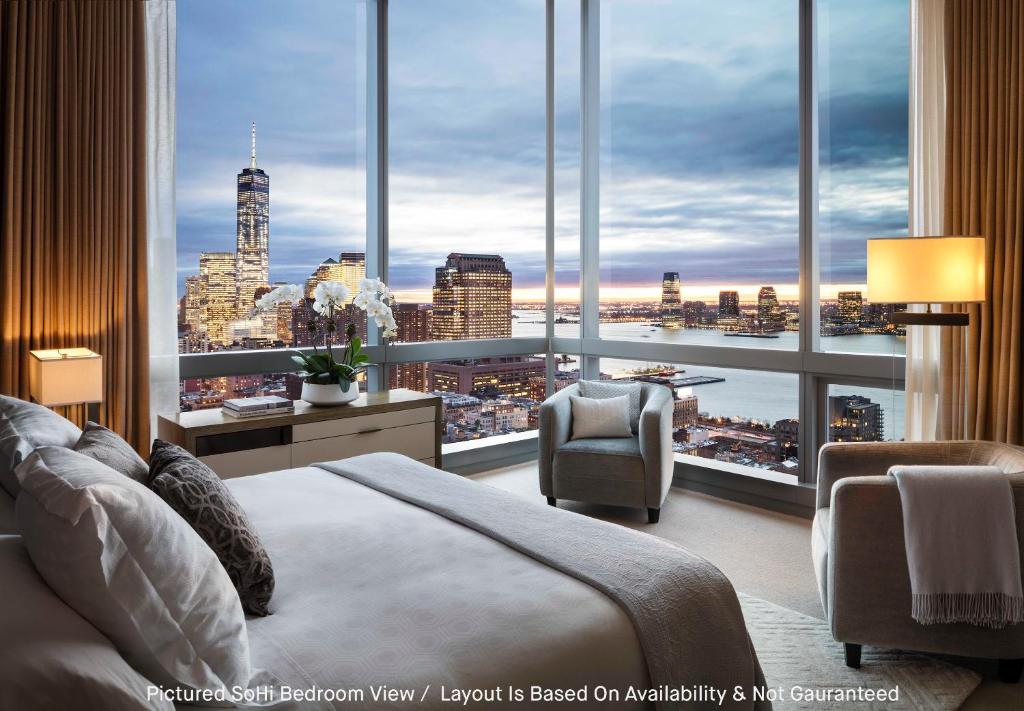 a bedroom with a large window with a view of a city at The Dominick Hotel in New York